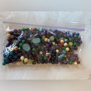 Misc. glass and wooden colored beads w/some silvertone circles. Weighs 3.64 ozs.
